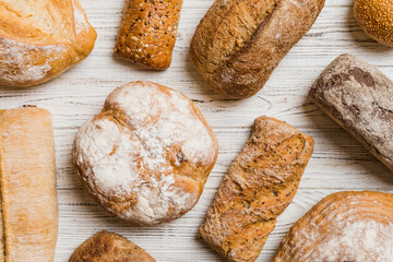 Naklejka premium Homemade natural breads. Different kinds of fresh bread as background, top view with copy space