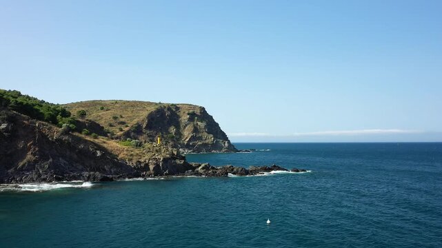 Scenic view of a rugged coastline with rocky cliffs and deep blue sea near Banyuls sur Mer, under a clear sky. Mediterranean landscape with natural coastal beauty.