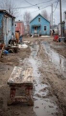 Fototapeta premium Rustic Bench Beside Muddy Road in Impoverished Neighborhood, Gloomy Day