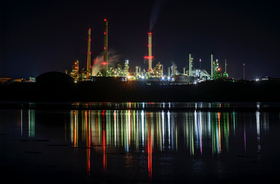 Valero Oil Refinery illuminated at night with colorful reflections in water