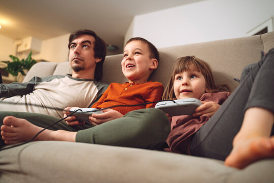 Family enjoying videogame together on sofa at home