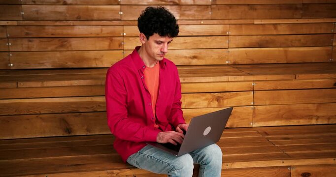 Happy, smiling, successful man freelancer using laptop copywriter typing on keyboard
