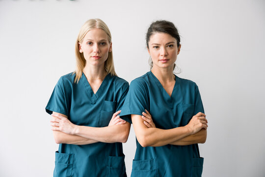 Exhausted nurse portrait in scrubs looking at camera in hospital