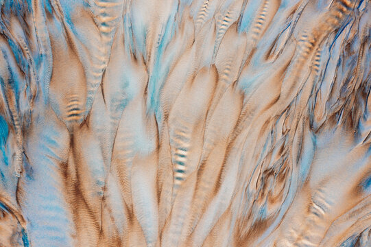 Aerial view of the pale cream and brown pattern with streaks of blue, a mesmerizing abstract landscape from above, Siemiatycze, Podlaskie Voivodeship, Poland.
