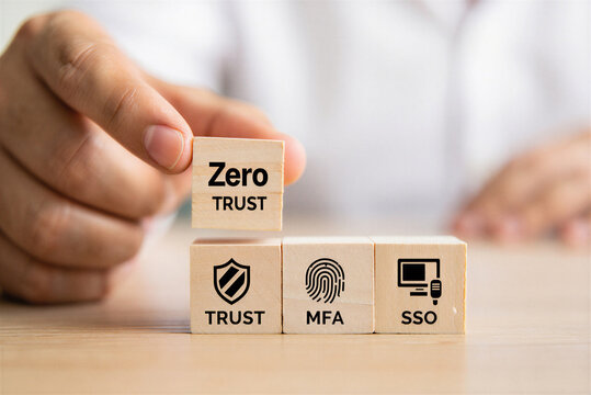 Person placing wooden blocks with security icons and text illustrating zero trust MFA and SSO concepts