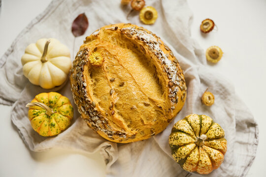 Artisan sourdough bread with pumpkins and seeds on linen in autumn