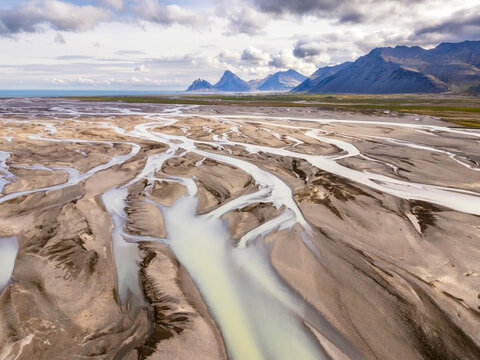 Braided glacial river in volcanic black sand plains with Icelandic peaks
