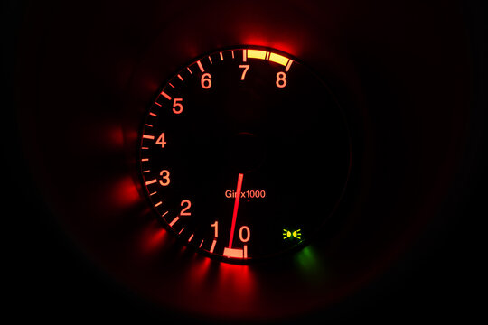Modern car tachometer illuminated in red at idle
