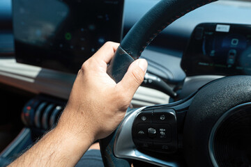 Action of driver is tight holding on steering wheel during driving a car. Close-up with selective focus.
