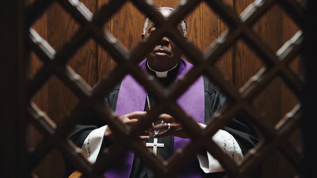 African American male priest in black robe and purple stole sits in confessional, adjusting his attire while framed by wooden lattice, creating a solemn atmosphere