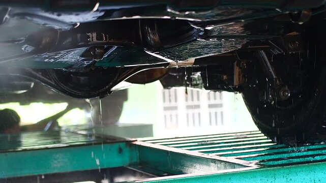 High-Pressure Water Washing Car Chassis and Undercarriage at a Service Station