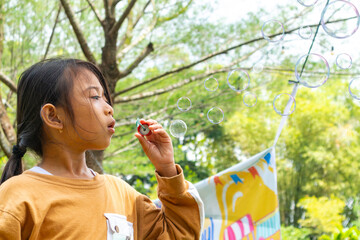 Happy Asian little girl playing bubble in outdoor