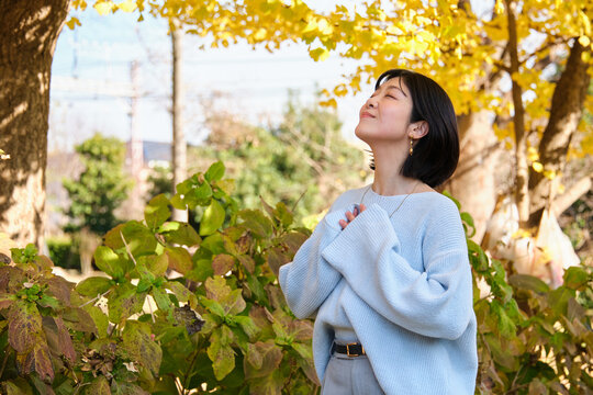 Woman enjoying deep breath in nature during autumn outdoors