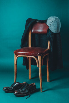 Empty chair with jacket, hat and shoes evoking quiet domestic memory