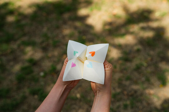 Young woman operating paper fortune teller aka chatterbox 
