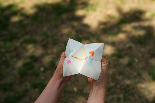 Young woman operating paper fortune teller aka chatterbox 