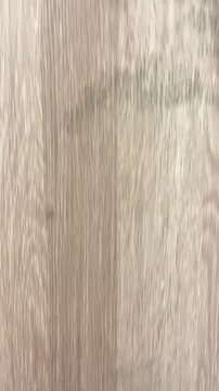 A close-up of a hand pointing to mold stains on the exterior panel of a wood-look furniture piece. The mold was caused by high humidity and poor indoor climate.