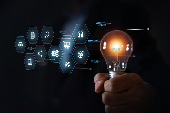Businessman's hand is choosing light bulb with business creativity icons for plan to goal or creative idea innovation or analyzing marketing data management and target growth or human resources.