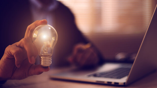 Businessman's hand is choosing light bulb for business creativity plan to goal or creative idea innovation or analyzing marketing data management and target growth or human resources.