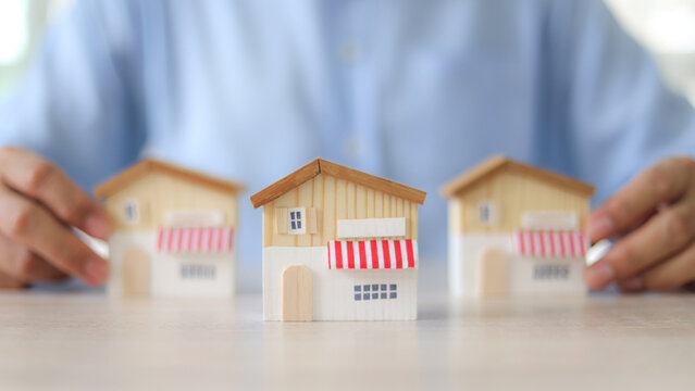 Businessman's hand chooses wooden toy franchise store for goal to growth is investment planning financial and branch expansion and management bank loans for marketing franchising.