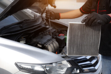 Auto mechanic holding car air conditioner filter for check and clean dirty or fix repair heat have engine problem or replace new change air filter of car care maintenance servicing concepts.