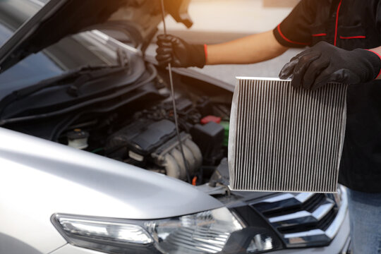 Auto mechanic holding car air conditioner filter for check and clean dirty or fix repair heat have engine problem or replace new change air filter of car care maintenance servicing concepts.