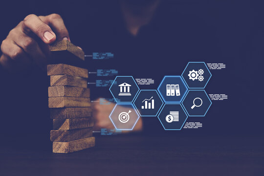 Close-up hand prevents and choose wooden block not falling with financial risk management icons for strategic planning and business challenge plan or safety insurance.