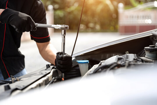 Auto mechanic holding wrench for fix service repairing and car care maintenance servicing change spare part engine problem or insurance support or range of car check or training workshop.