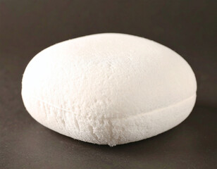 A minimalist macro shot of a soft, white textured object on a dark background, evoking purity and calm. Ideal for wellness, skincare, or abstract design, highlighting organic simplicity.