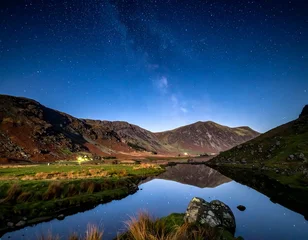 Poster Reflectie Scenic nightscape featuring mountains reflected in calm water under a starry sky  © hazfre