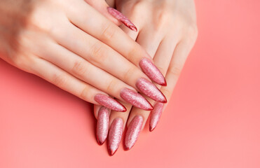 Fototapeta premium Woman's hands showing long pink almond nails with red tips