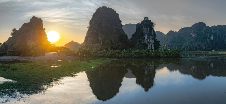 Sunrise over majestic karst mountains and tranquil rice paddies in Tam Coc, Ninh Binh, Vietnam. Serene natural beauty. Hang Mua.