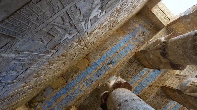 Ancient Egyptian Dendera Temple. Ornate hieroglyphic ceiling and massive stone columns with original blue pigment preserved. Perfect for history documentaries.. Downscaled from 6k.