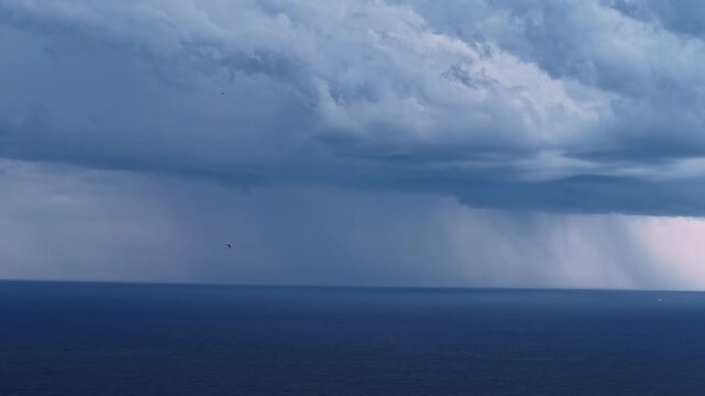 Approaching storm system over marine horizon with precipitation
