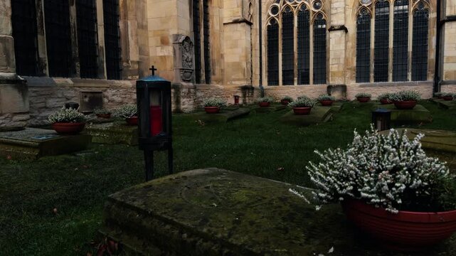 Historic cloister graveyard at St Paulus Dom in M&uuml;nster, Germany. Stone tombs and memorial lanterns in cathedral courtyard creating a quiet atmosphere of remembrance and faith.