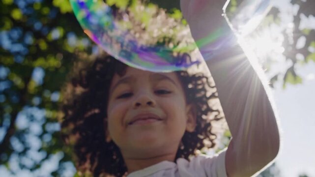 black girl blowing bubbles in park sunlight, curly hair, white dress, green trees, sun flare, iridescent giant bubble, low angle perspective, joyful smile, summer meadow, carefree play, slow motion