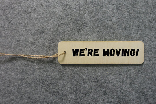 Wooden tag announcing we are moving for a new beginning