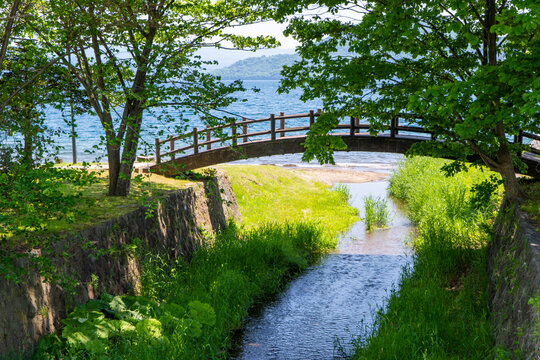 Early Summer Park Landscape with Wooden Bridge and Stream at Ukimido Park, Lake Toya, Hokkaido, Japan