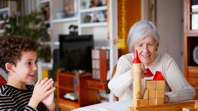 Grandmother and grandson building a wooden block tower together