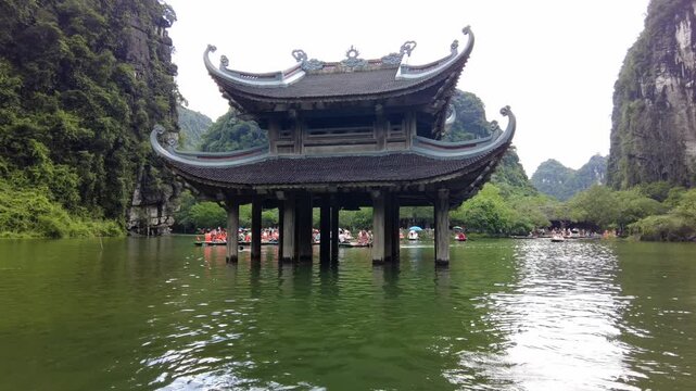 Asia , Vietnam , Trang An  03,04,2026 Thuy Dinh Pagoda emerges from the water - UNESCO World Heritage - Traditional boats carry tourists on the river - tourist attraction  sightseeing close to Ninh Bi
