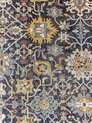 Obraz premium Intricate floral and vine pattern on traditional dark oriental rug. Vintage style textile background with colorful details.