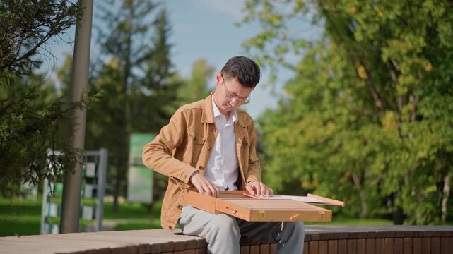 young asian artist painting sketchbook outdoors, capturing street scene from park bench, unfolding wooden sketchbox, mixing watercolor palette, focused student painter studying urban trees