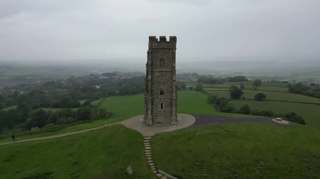 Cinematic Orbit Around St Michaels Tower on Glastonbury Tor with Somerset Town in Background