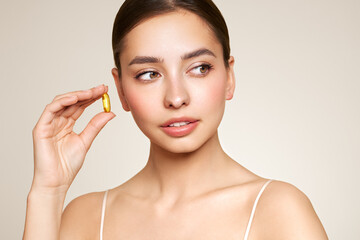 Vitamins. Close Up Of Happy Beautiful Girl With Pill With Cod Liver Oil Omega-3. Nutrition. Vitamin D, E, A Fish Oil Capsules. Healthy Lifestyle. Sport, Diet Concept