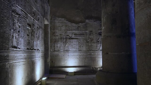 Dendera temple interior sanctuary with illuminated hieroglyphic walls and ritual reliefs in Egypt, ancient sacred chamber with dramatic lighting on carved sandstone surfaces.