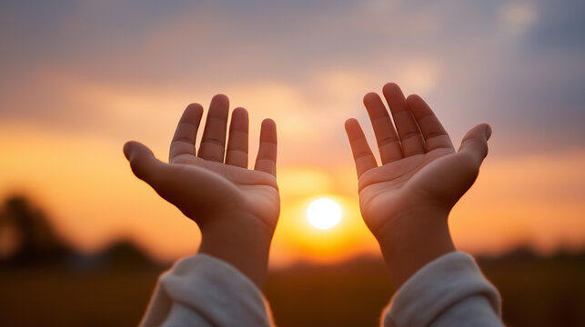 Close-up of open palms facing skyward against a vibrant sunset sky, defocused warm horizon glow below, prayer, surrender, faith, hope, devotion, God's blessing, spiritual worship, Christianity,