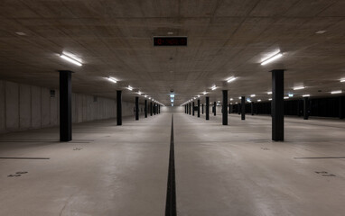 Naklejka premium Front view of a new light-colored public parking lot with black stripes and columns. Nobody inside