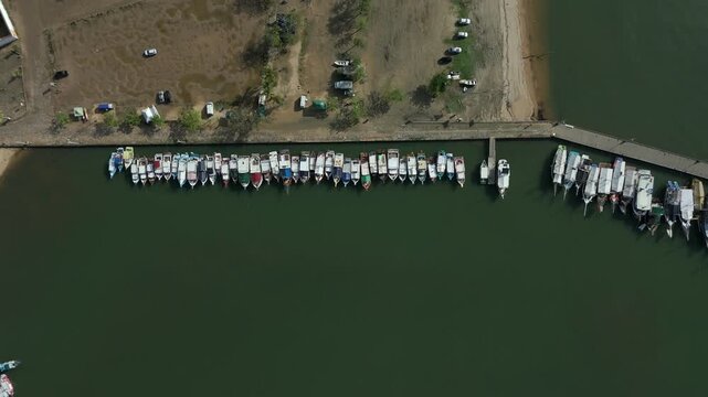 Top View Of Traditional Wooden Boats Docked Along The Riverfront In Paraty, Brazil. Aerial Ascending Shot