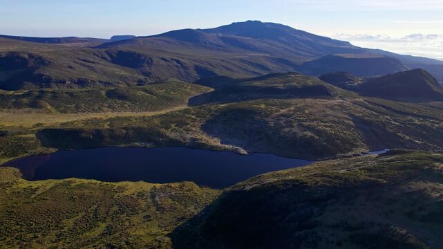 Aerial view of Lake Ellis nestled amid the rugged terrain of Mt Kenya, showcasing a tranquil body of water surrounded by the undulating landscape, Lake Ellis, Meru County, Kenya.