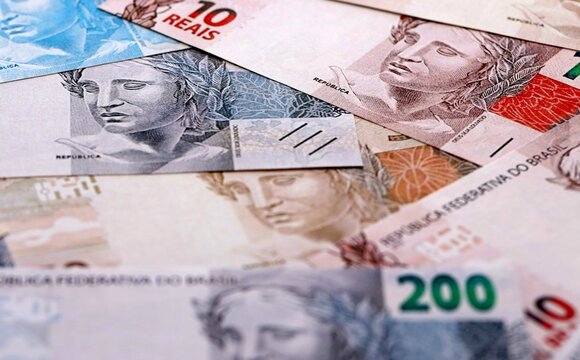 Brazilian real money bills pile on table. Brazil banknotes of BRL currency close up.